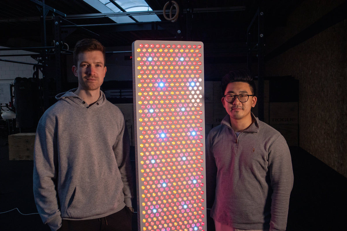 Two people behind Resty standing next to an illuminated Resty red light panel